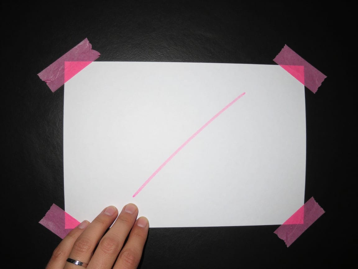 Flash photo of a printed sheet taped to a black wall with pink gaffer tape